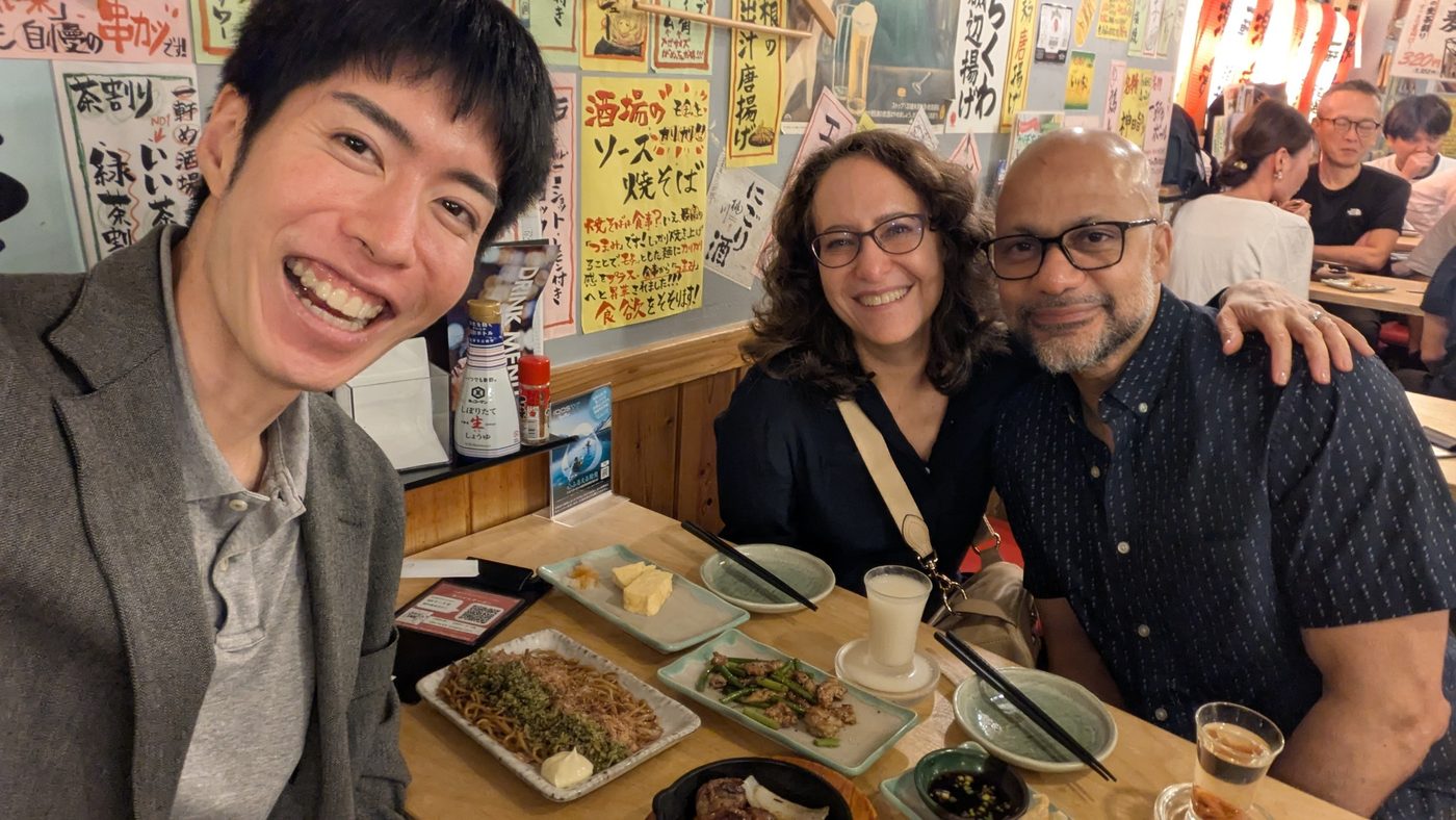 Guests enjoying izakaya dishes at a table