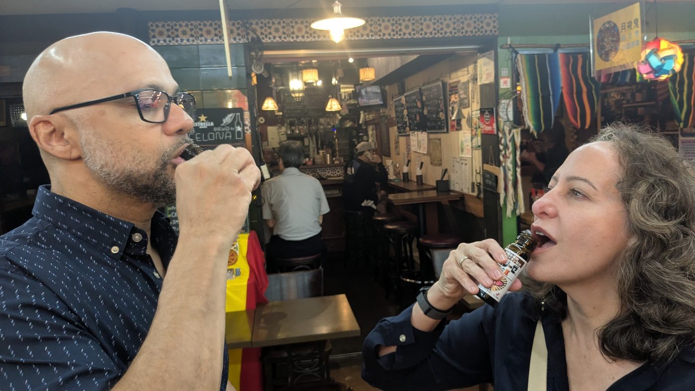 Two guests toasting at an izakaya counter